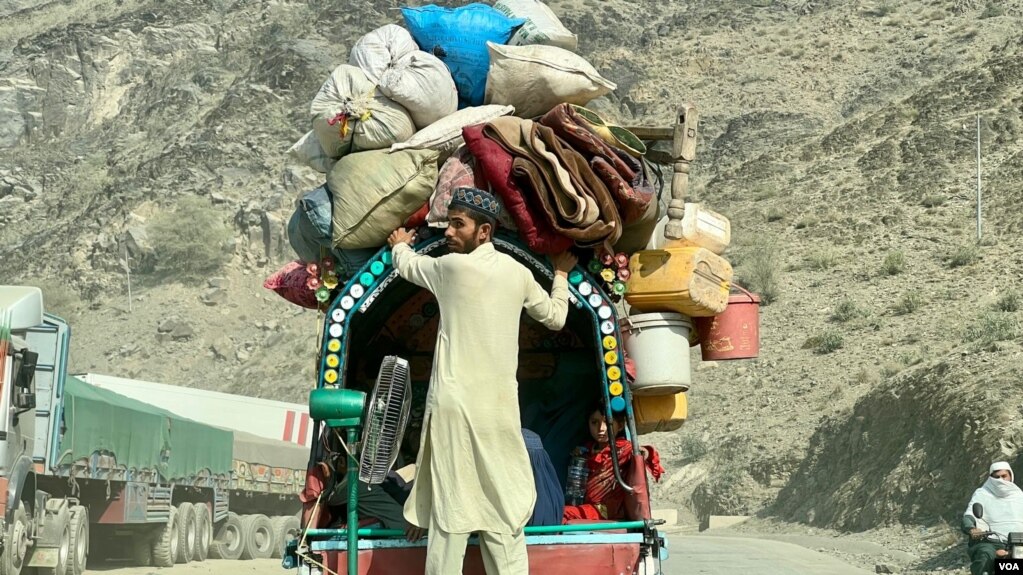 An Afghan family travelling with belongings on a heavily loaded vehicle near the Pakistan–Afghanistan border
